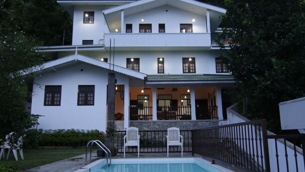 A two-story white building with a swimming pool in front. - Muduna Walawwa Resort (Kandy)