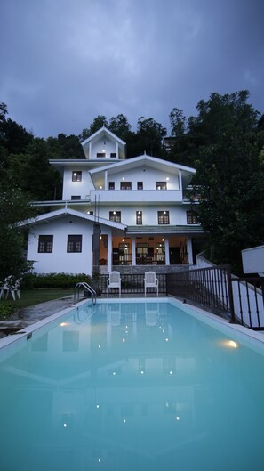 A two-story white building with a swimming pool in front. - Muduna Walawwa Resort (Kandy)