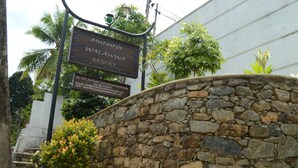 A stone wall with a sign for Mudumudi Walawwa Resort. - Muduna Walawwa Resort (Kandy)