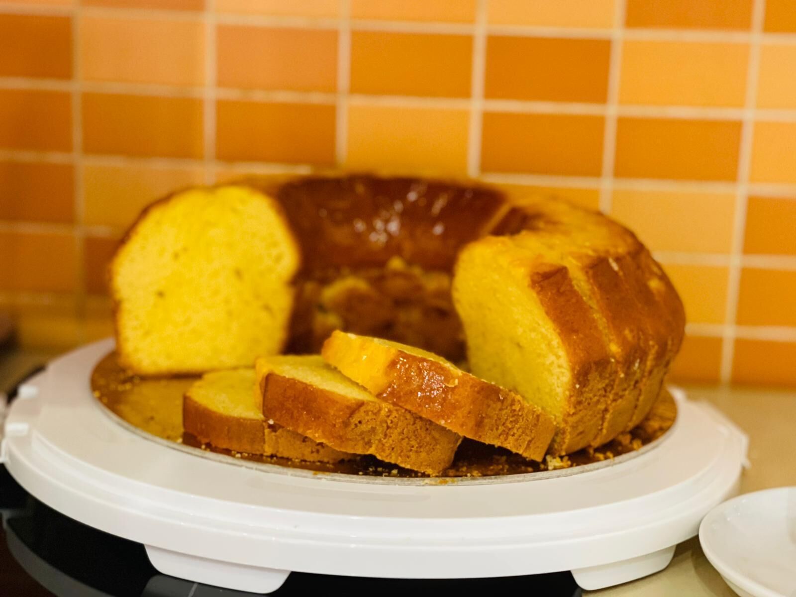 Ein Bundt-Kuchen auf einem weißen Teller, mit bereits angeschnittenen Stücken.