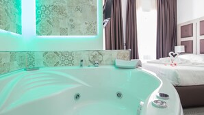 A modern hotel room with a large bathtub, a neatly made bed, and a shower area. - Vatican Relais Rome (Rome)