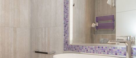 A modern bathroom with a large mirror, a bidet, and a glass-enclosed sink.
