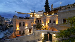 A historic building with multiple balconies, a rooftop terrace, and a sign indicating it is a hotel. - Taskonak Hotel (Nevsehir)