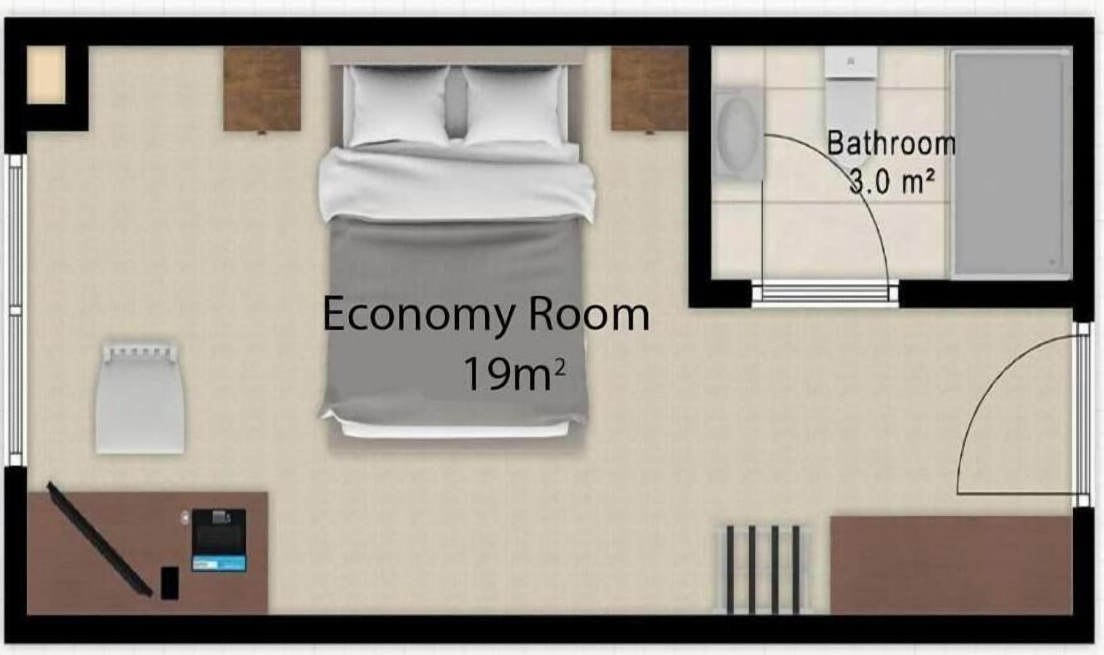An economy room with a bed, a desk, and a bathroom.