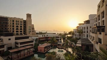Un resort con piscina, palmeras y edificios con balcones.