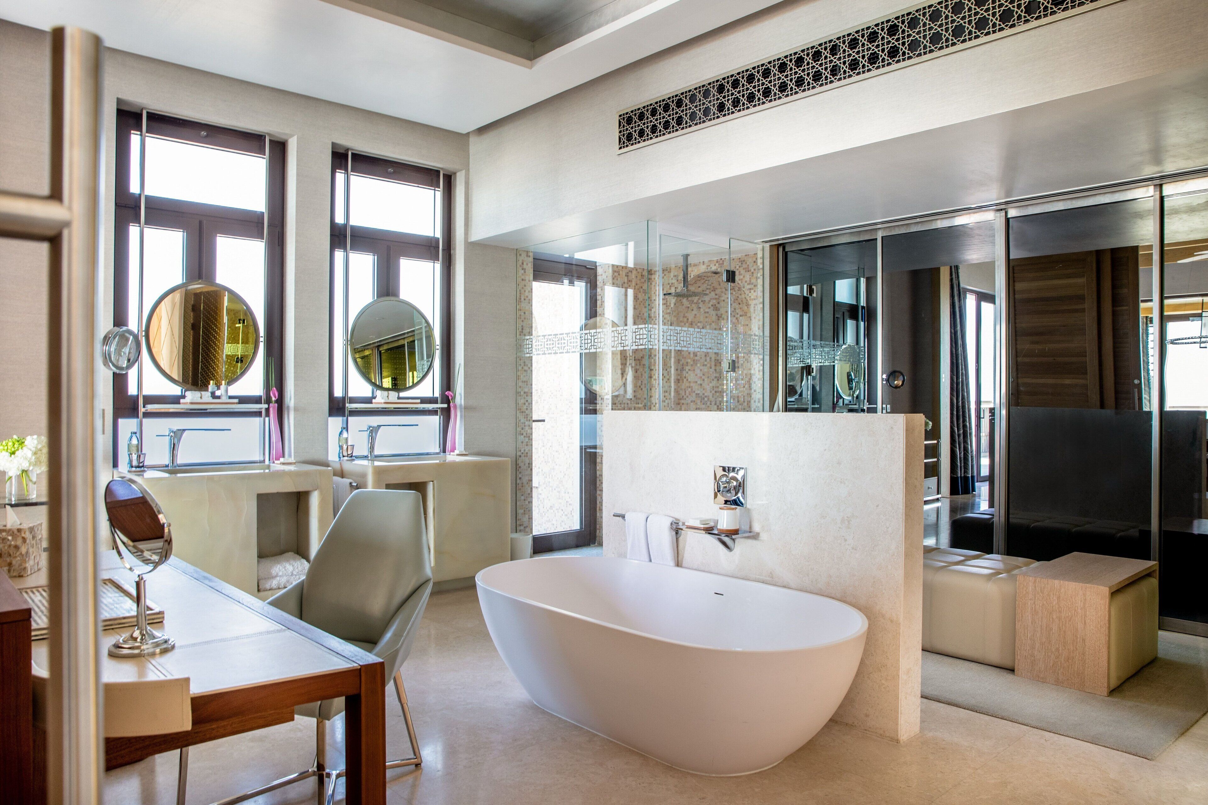 Ein modernes Badezimmer mit einer freistehenden Badewanne, einem Waschtisch inklusive Spiegel und einer separaten Duschkabine.