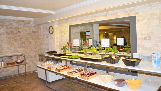 Un buffet garni de divers plats et une horloge accrochée au mur.