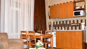Un espace de vie compact comprenant un coin repas, une kitchenette et un canapé.