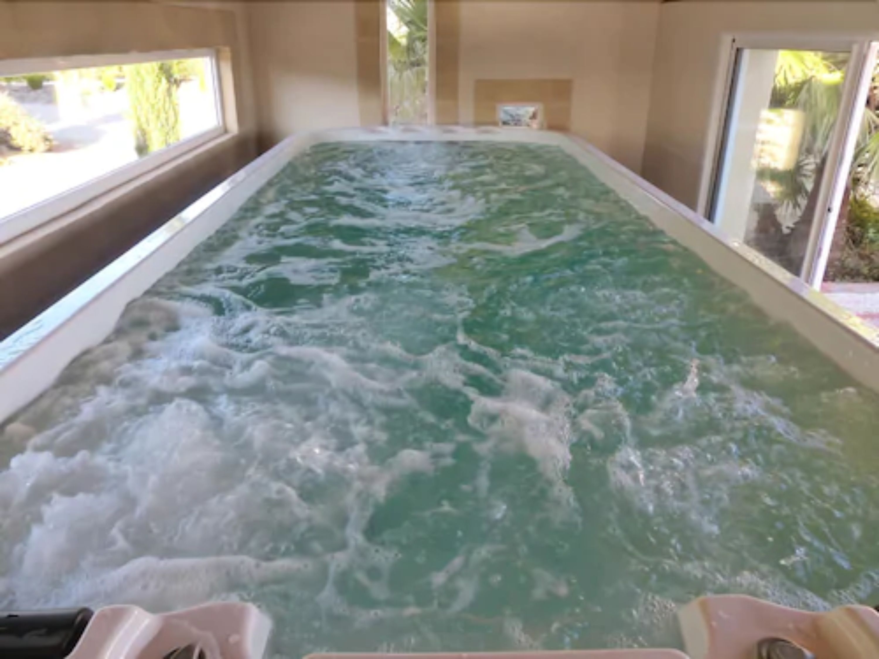 Un bain à remous avec vue sur l’extérieur grâce à de grandes fenêtres.