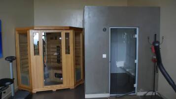 A room with a wooden cabinet, a glass door, and a vacuum cleaner.
