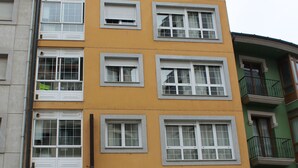 A multi-story building with a yellow facade and white-framed windows. There is a sign for a restaurant and a hostel named 'Hostal dp Cristal' with a white awning. - Hostal DP Cristal (Sarria)