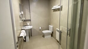 A modern bathroom with a glass shower enclosure, a toilet, and a sink. - Hostal DP Cristal (Sarria)