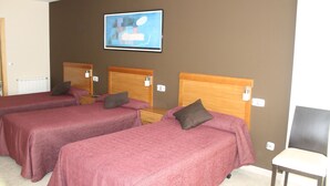 A hotel room with two single beds, wooden headboards, a small bedside table with a lamp, and a framed picture on the wall. - Hostal DP Cristal (Sarria)
