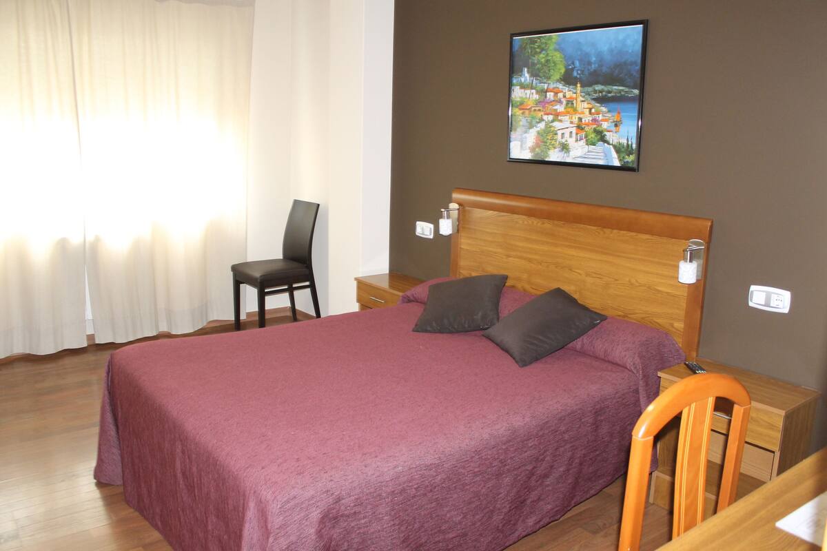 Premium bedding, desk, laptop workspace, blackout drapes