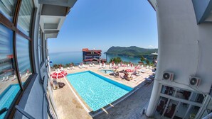 A pool area with a view of the sea, a building labeled 'GÜNTER SEHER', and outdoor seating. - Diamond Hotel (Amasra)