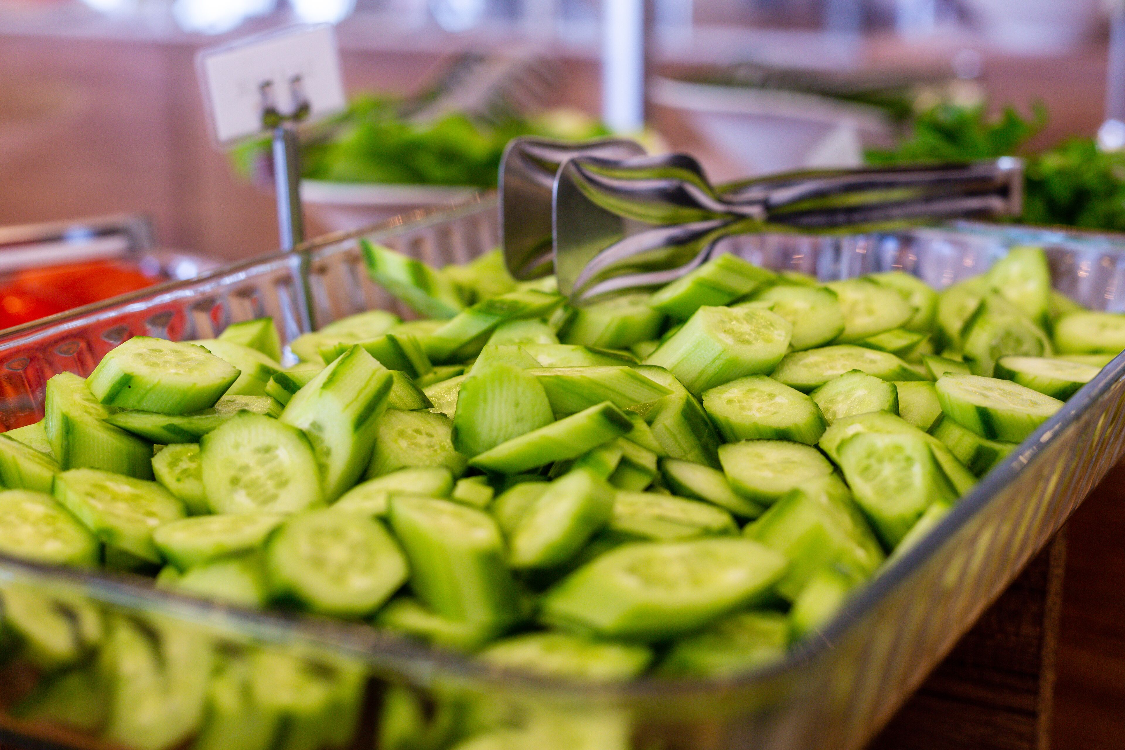 A glass container filled with sliced cucumbers.