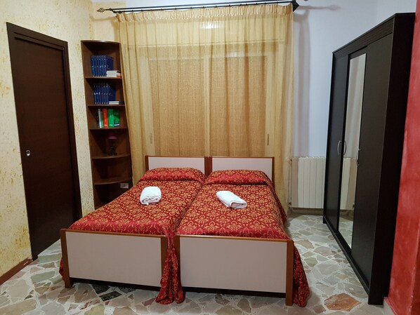 Une chambre à coucher avec un lit double, une bibliothèque et une armoire.