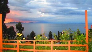 Vista de un lago con una valla de madera al frente.