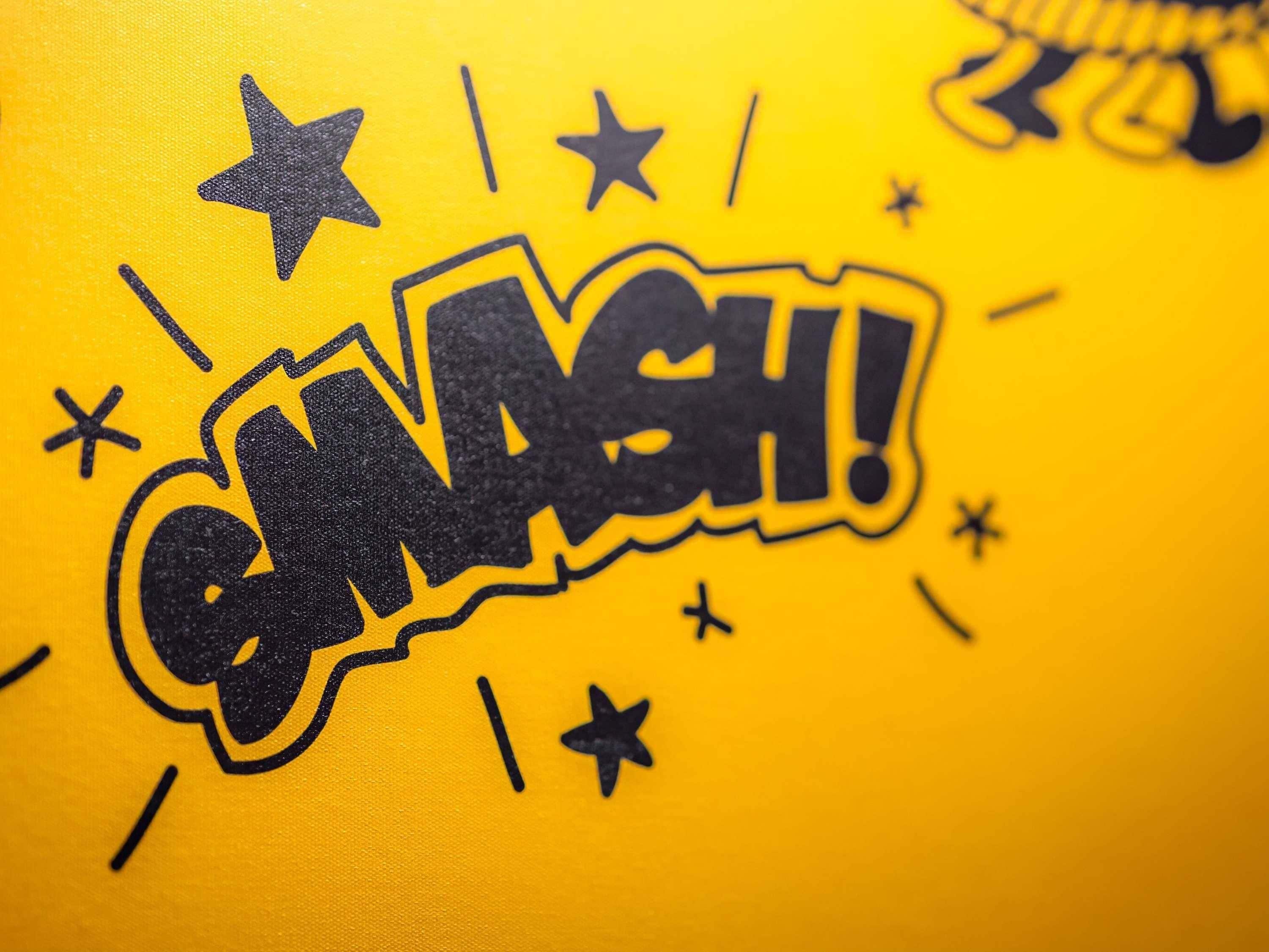 Superficie amarilla con un gráfico negro que muestra la palabra 'CRASH!' rodeada de estrellas.