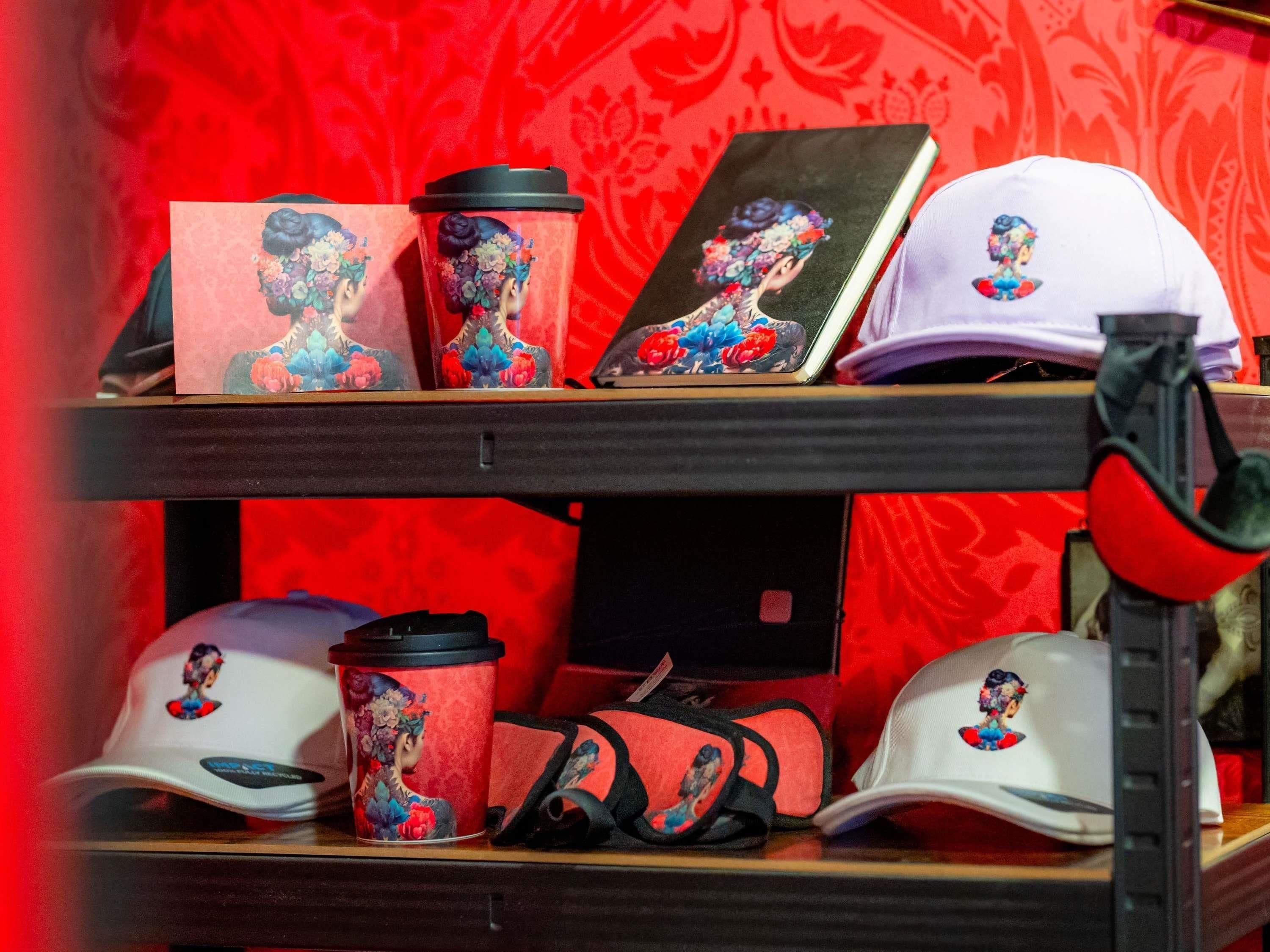 A shelf with various items including a red patterned cup, a white cap, and a book with a floral design.