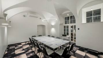 A conference room with a long table, chairs, and a patterned carpet.