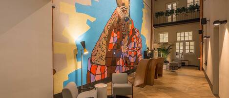 A modern lobby with a colorful mural, comfortable seating, and a spacious layout.