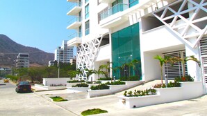 A modern building with multiple balconies, large windows, and a geometric facade.