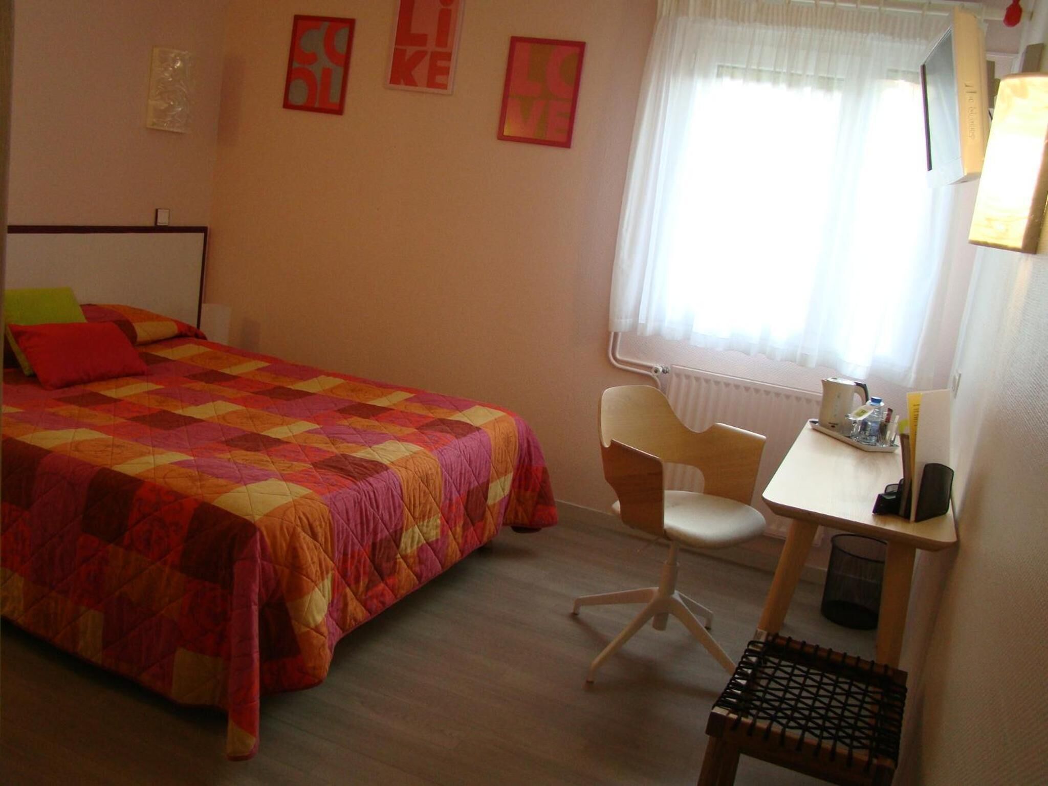Un dormitorio con una cama, un escritorio y una silla.