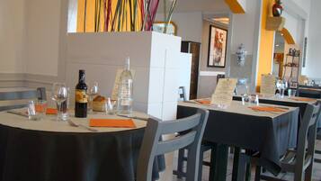 Ein Restaurantinnenraum mit runden Tischen, Stühlen und einem Menüständer.