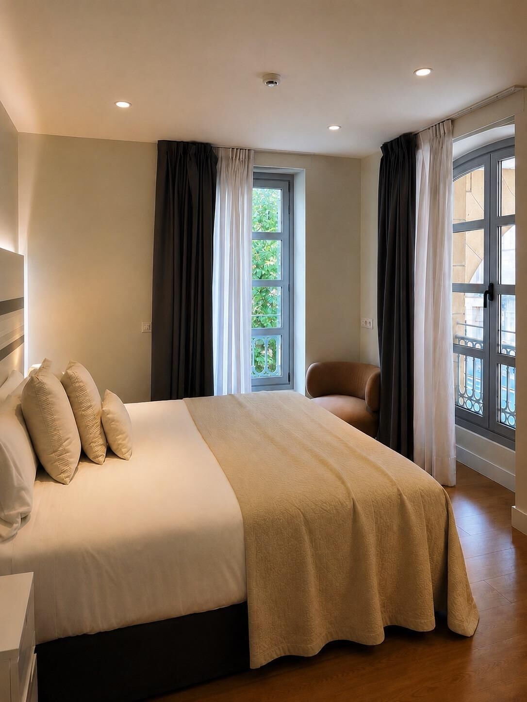 A bedroom with a bed, a chair, a window, and a door.
