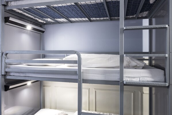 A bunk bed room with metal railings, a white door, and a skylight. - Astor Hyde Park – 18 to 40 years (London)