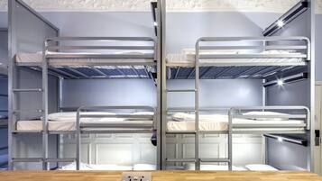 A bunk bed room with a wooden table in the foreground and a white ceiling with decorative molding.
