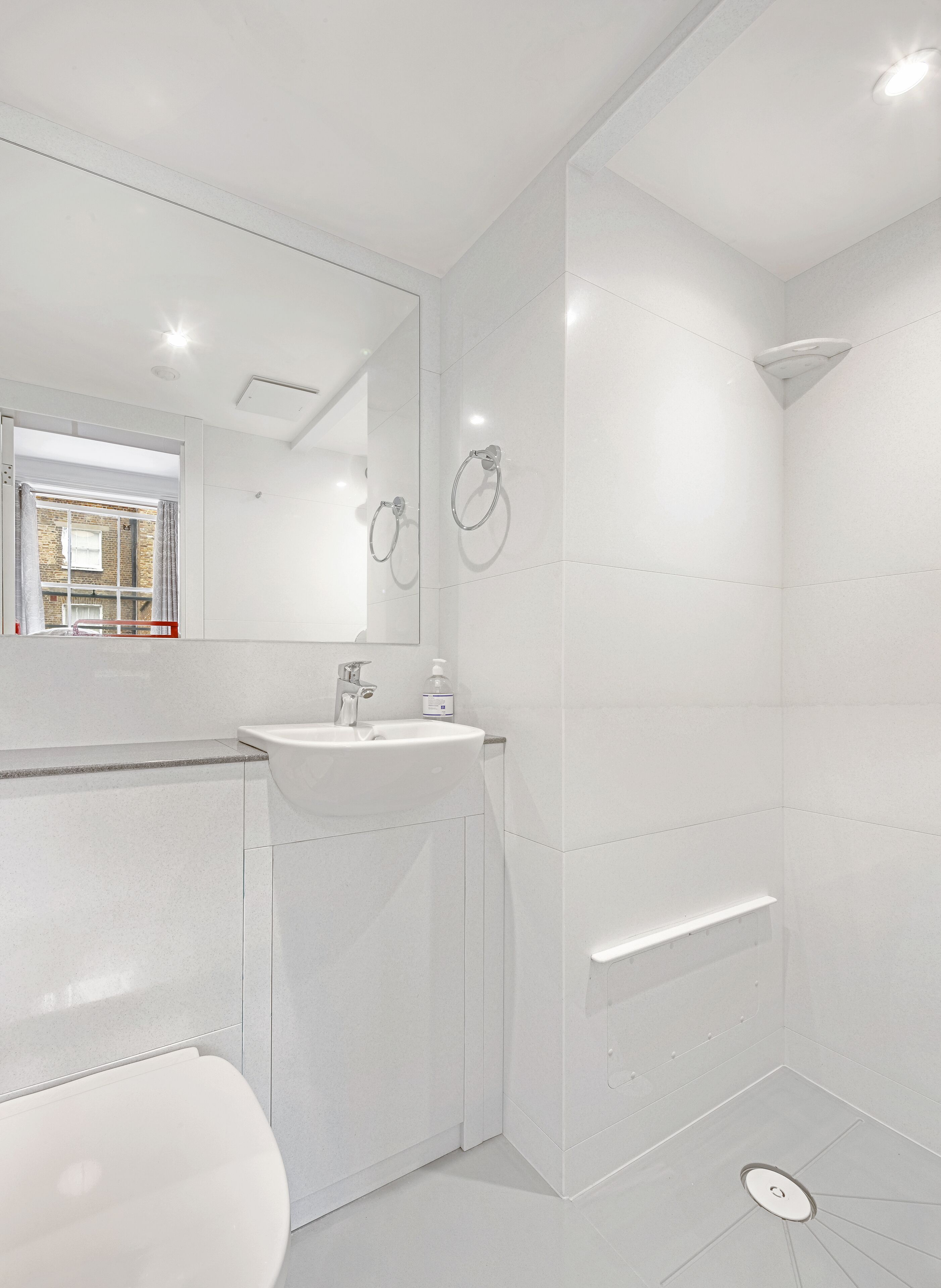 Une salle de bain moderne équipée de toilettes, d’un lavabo et d’une douche.