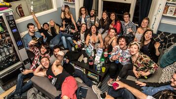 Un grupo de personas en una habitación con una zona de bar, asientos y una estantería.