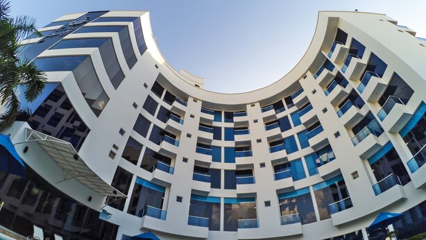 A modern hotel with a curved architecture, a swimming pool, and multiple balconies. - Hotel Florida Sinú (Montería)