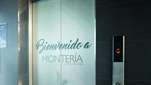 A hotel elevator with a frosted glass door displaying "Bienvenido a MONTERÍA HOTEL Florida Sini". - Hotel Florida Sinú (Montería)