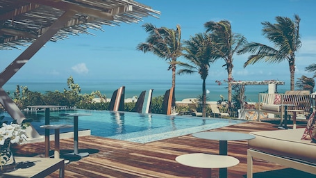 Una piscina al aire libre, sillones reclinables de piscina