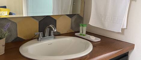 A bathroom with a white sink, a mirror, and towel racks.
