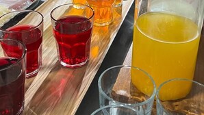 A buffet table with various dishes, drinks, and a large pitcher of orange juice. - Hotel Nuevo Mundo (San Rafael)