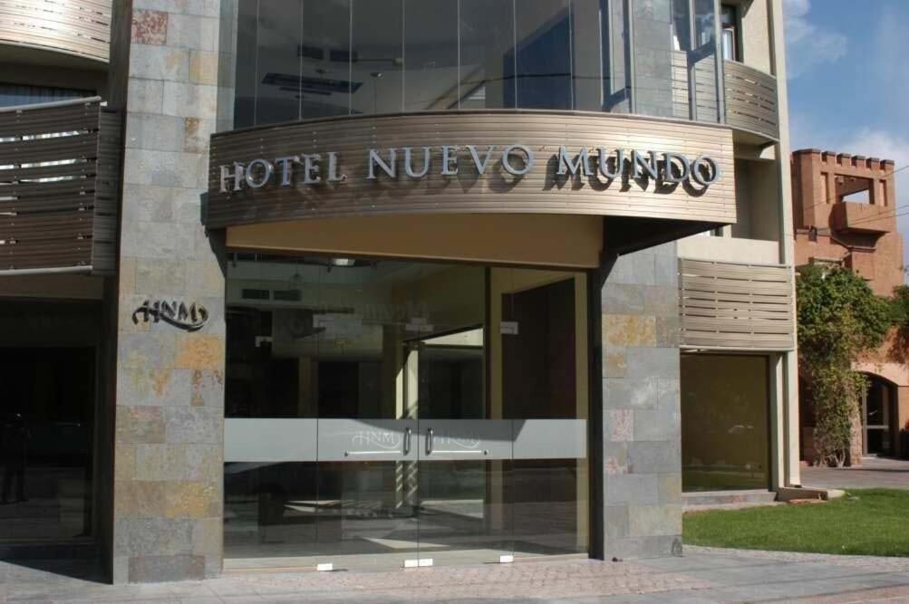 The exterior of Hotel Nuevo Mundo, featuring a modern facade with large glass windows and a prominent entrance.