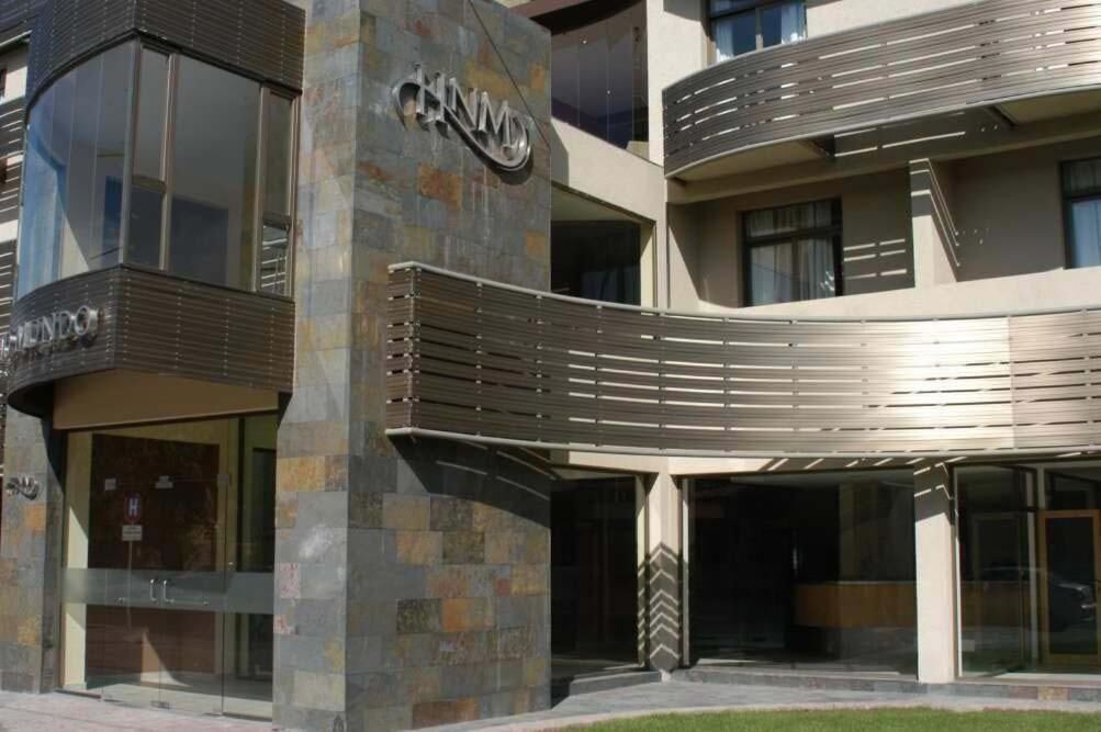 A modern building with a curved entrance, large windows, and a prominent sign.
