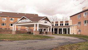 A multi-story building with a covered entrance labeled 'CARriage House.' - Carriage House Country Club (Pocono Manor)