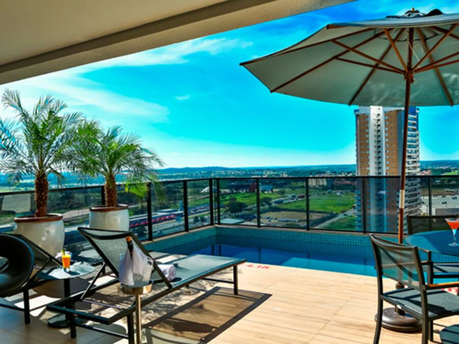 Un balcón con piscina, mobiliario exterior y vistas a la ciudad.
