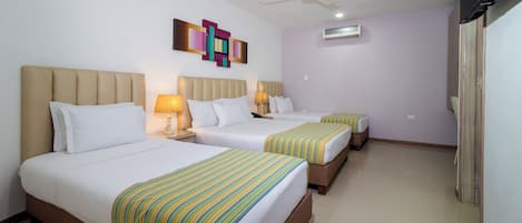 A hotel room with two beds, a ceiling fan, an air conditioning unit, and a colorful abstract painting on the wall.