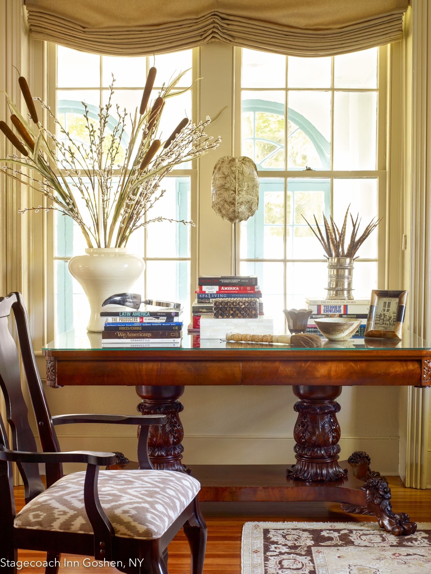 A room with a wooden table, a chair, and a window with a view of greenery.