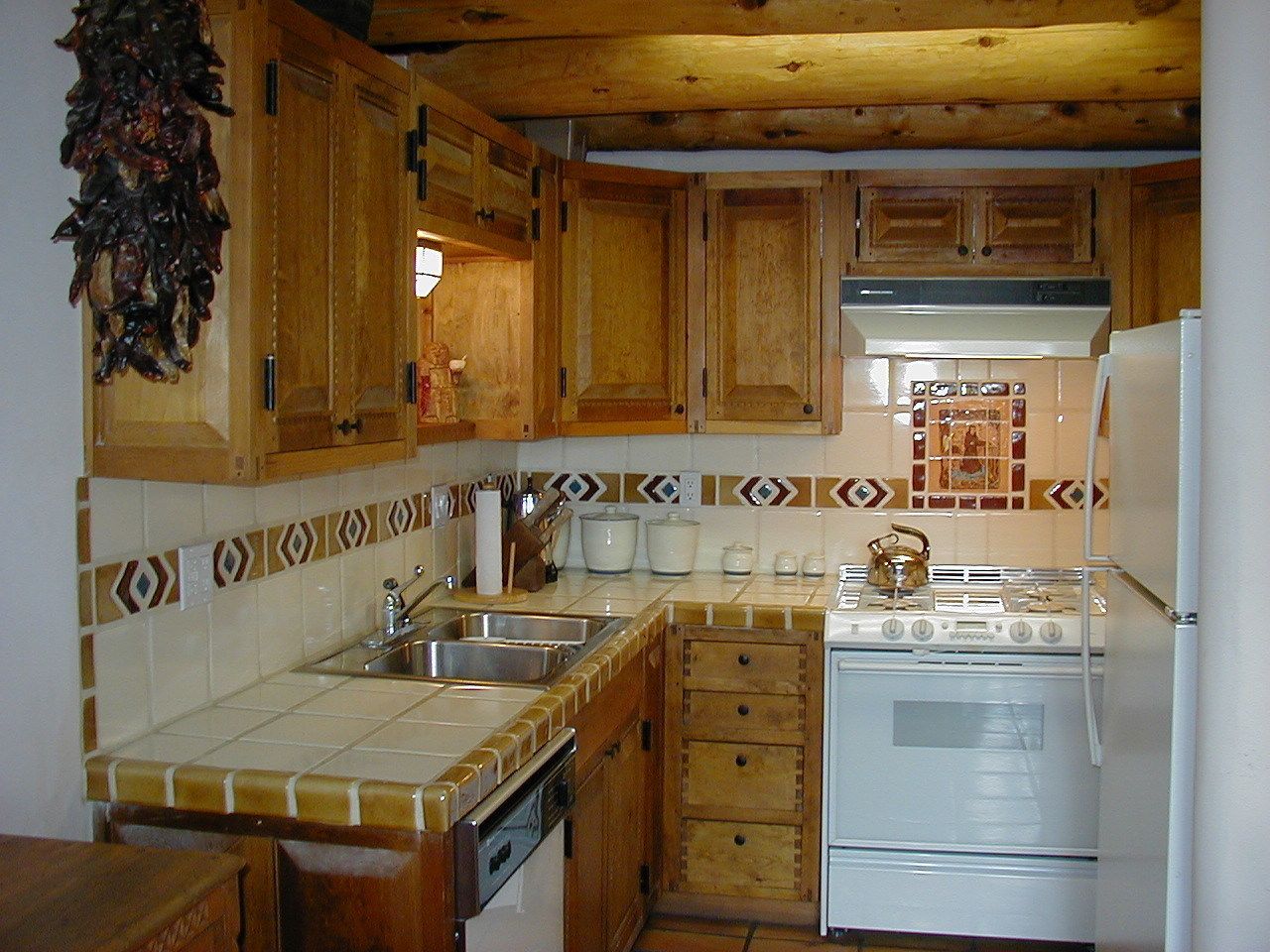 A kitchen with wooden cabinets, a stove, a sink, and a microwave.