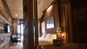 Un interno in legno con un letto, una sedia e una vasca da bagno.