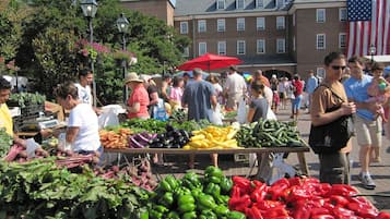 An outdoor market with various vegetables on display.