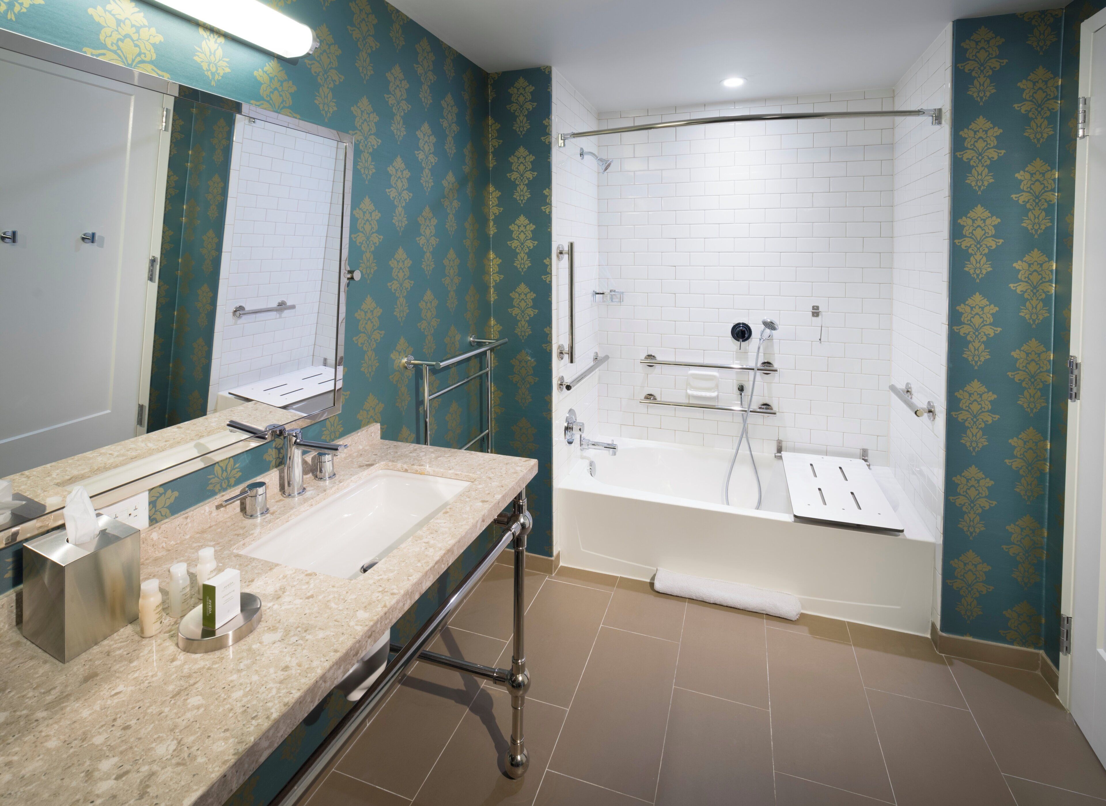 A bathroom with a double sink, a bathtub, and a shower area.