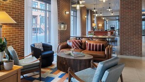Ein modernes Interieur mit Backsteinwand, Ledersofa, rundem Couchtisch und Pendelleuchten.